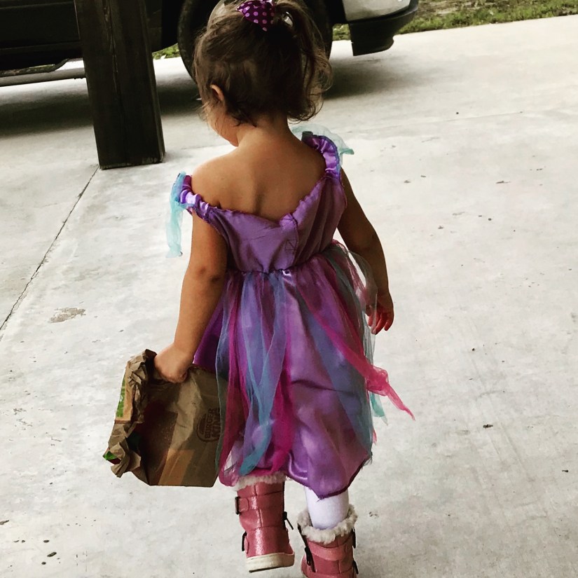 Little girl in a princess dress, furry boots, and a burger king bag. 