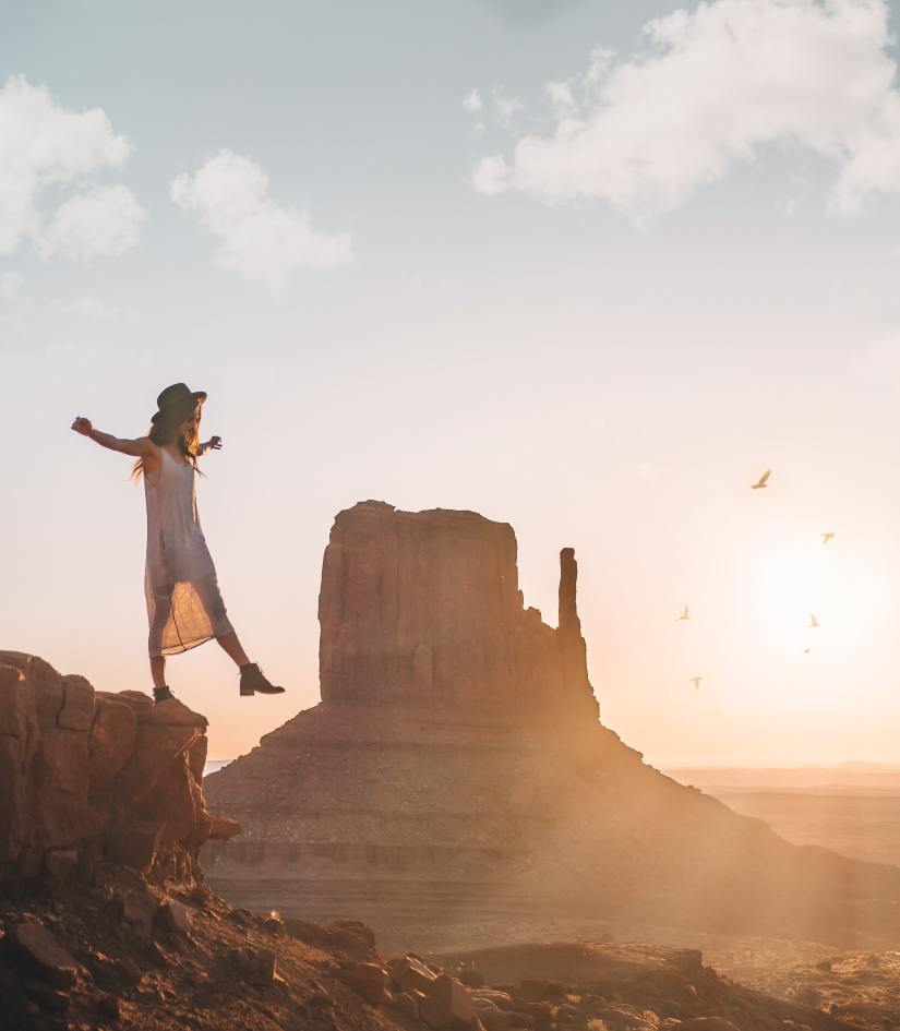 woman stepping off a small cliff in freedom